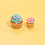 Vanilla Cupcakes with blue and pink buttercream icing and rainbow sprinkles on yellow background by Crumbs & Doilies